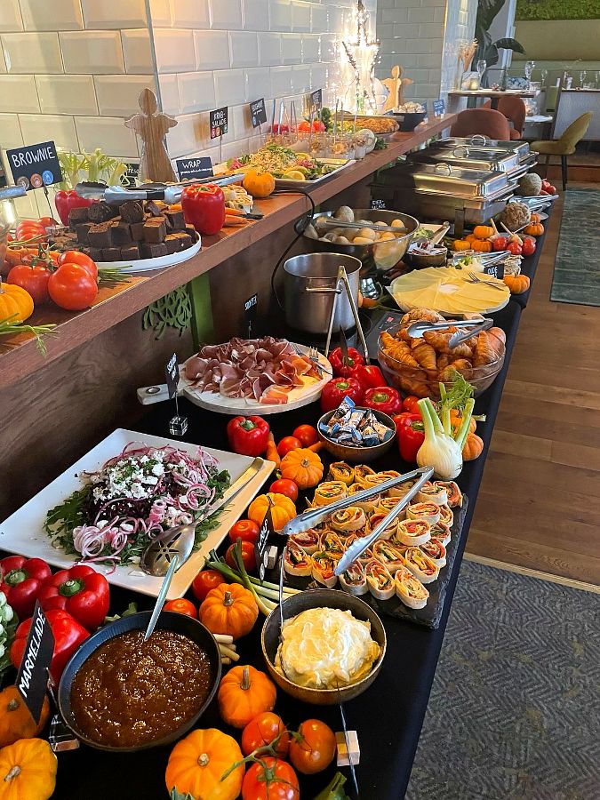 Buffettafel vol wraps, salades, ham, croissants en pompoentjes.